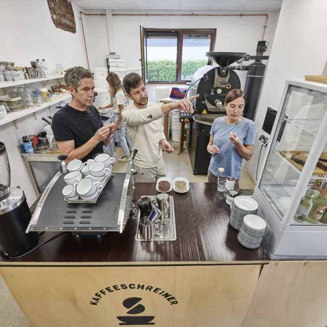 Kaffeeschreiner zeigt Kursteilnehmern auf Kaffeeschreiner Kaffeebar die Unterschiede bei Kaffeequalität