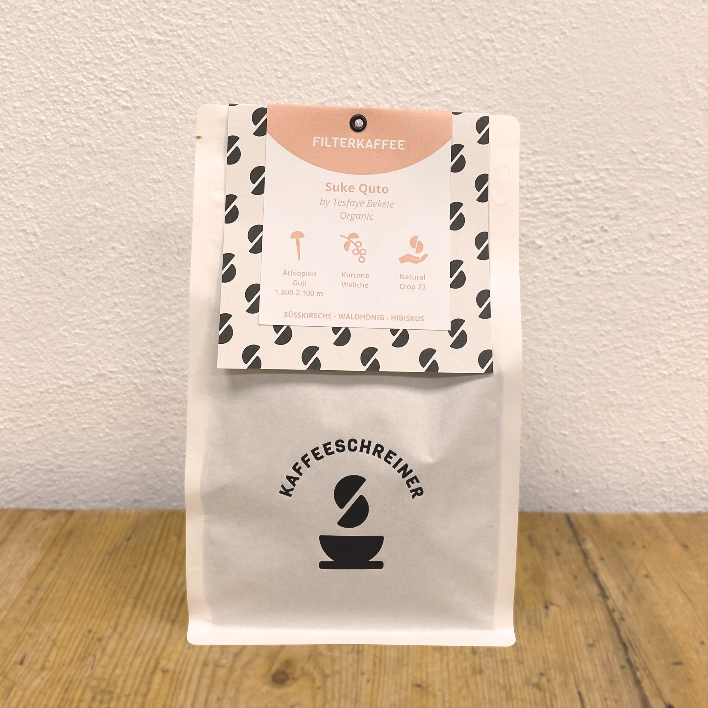 Weiße Kaffeeverpackung mit Kaffeeschreiner Logo von Suke Quto Natural