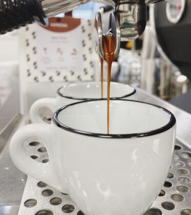 Espresso Tasse in die Espresso aus der Siebträgermaschinen Brühgruppe fließt